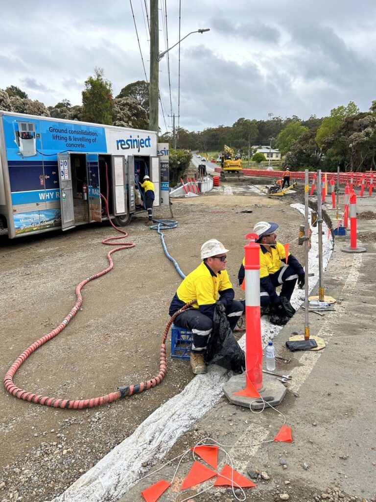 Resinject technicians injecting resin through small holes in the ground